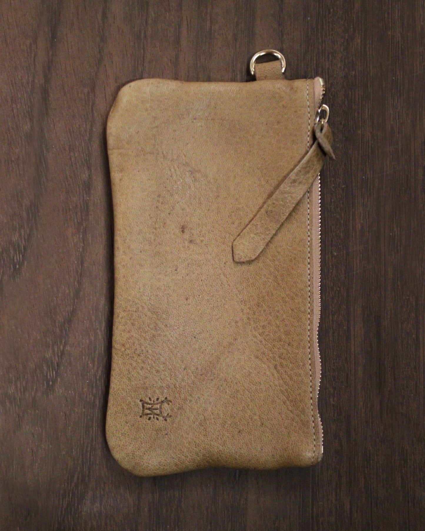 Brown leather zip pouch with acorn embossing from BAY TINE TANNERY, featuring a compact design and smooth zipper closure.